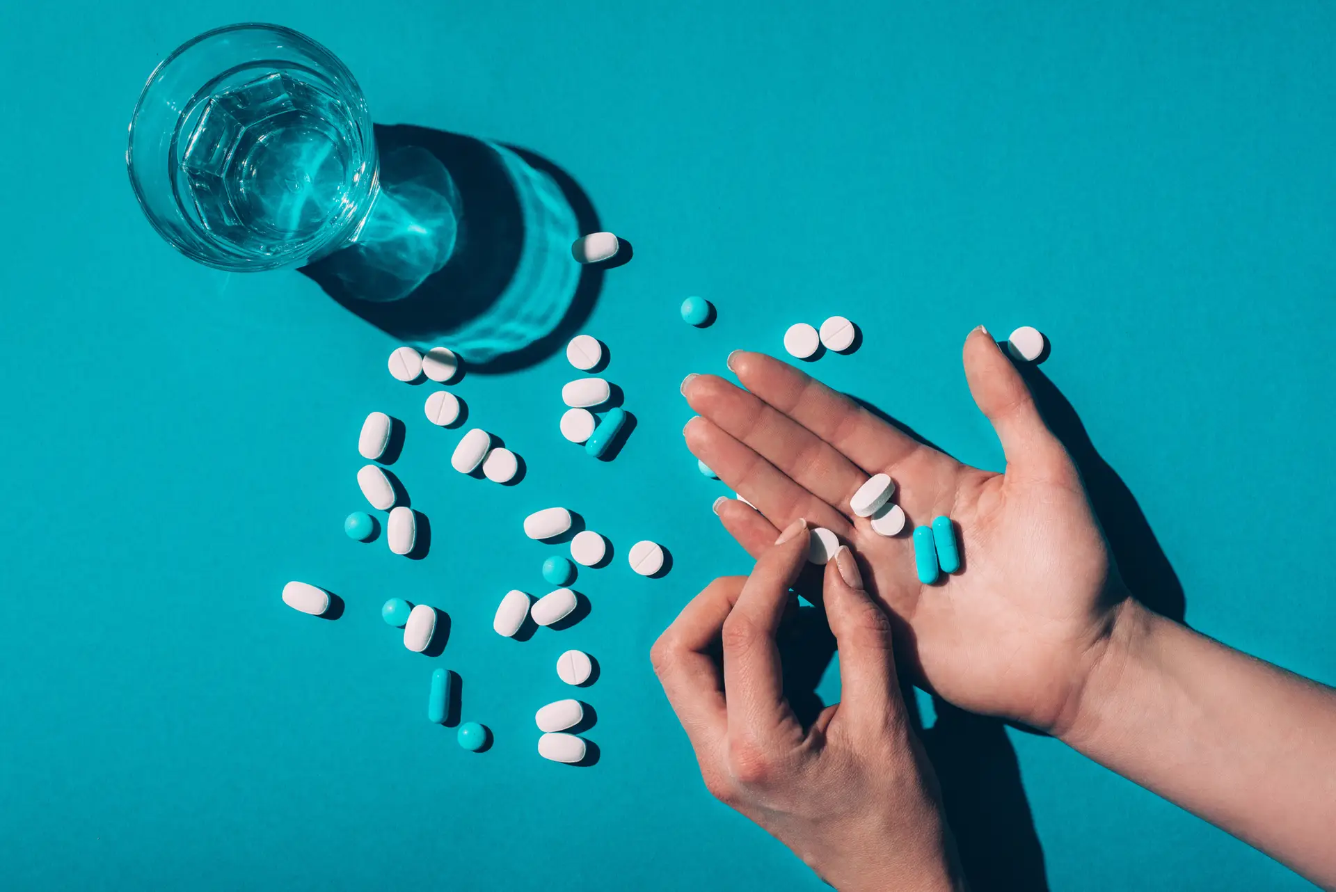 Pill in hands and water in glass