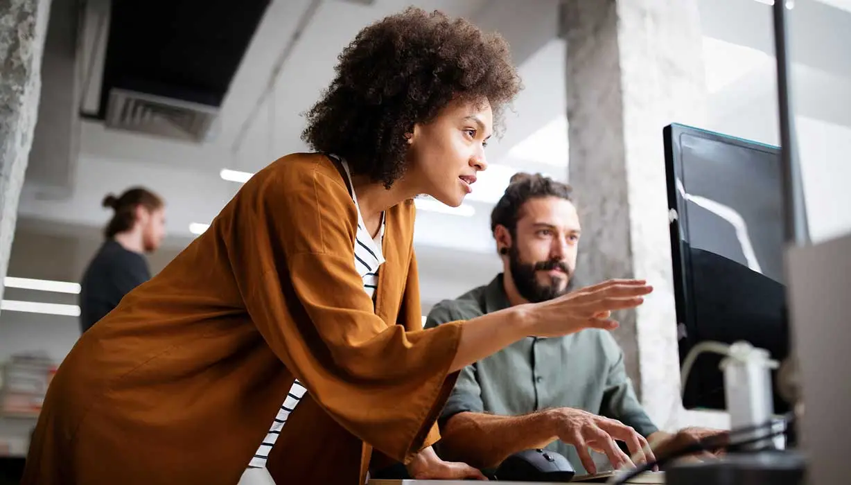 two coworkers looking at monitor
