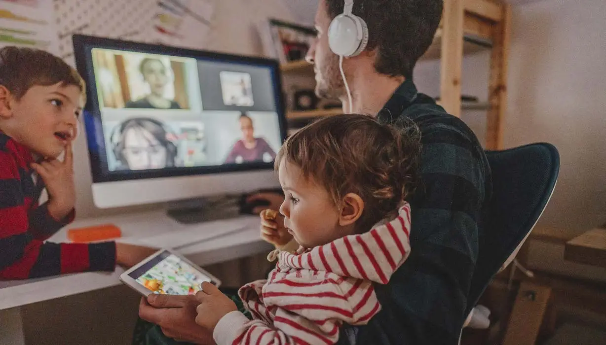 man on virtual meeting holding a child