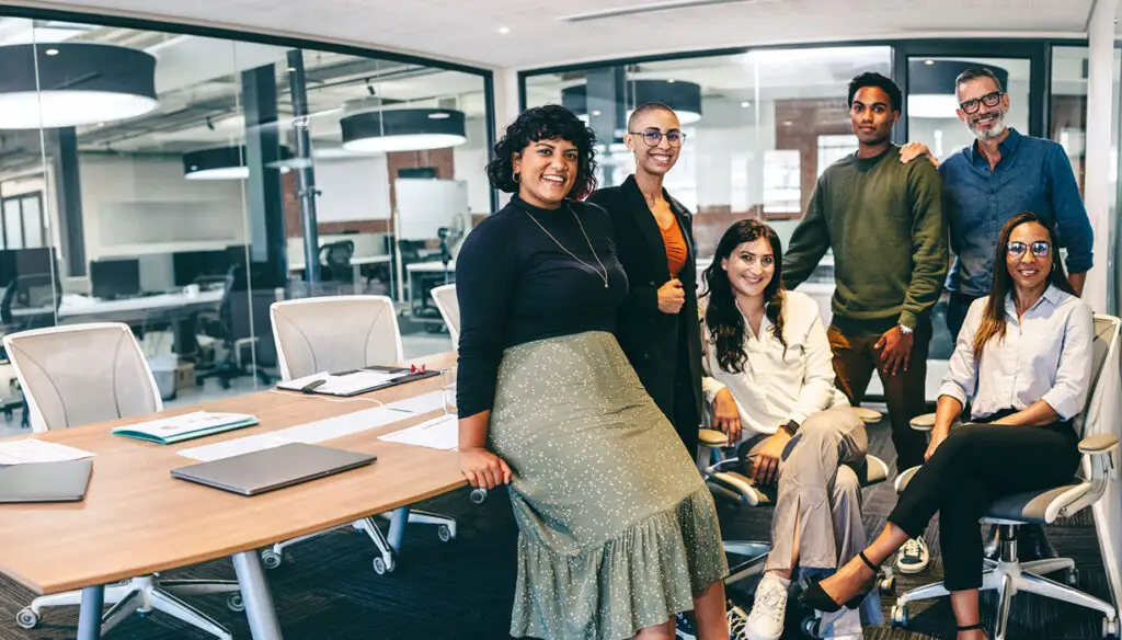 six smiling co-workers in a conference room