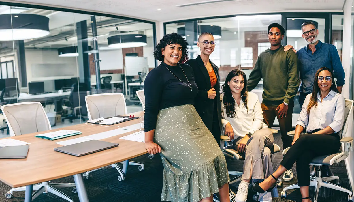 six smiling co-workers in a conference room