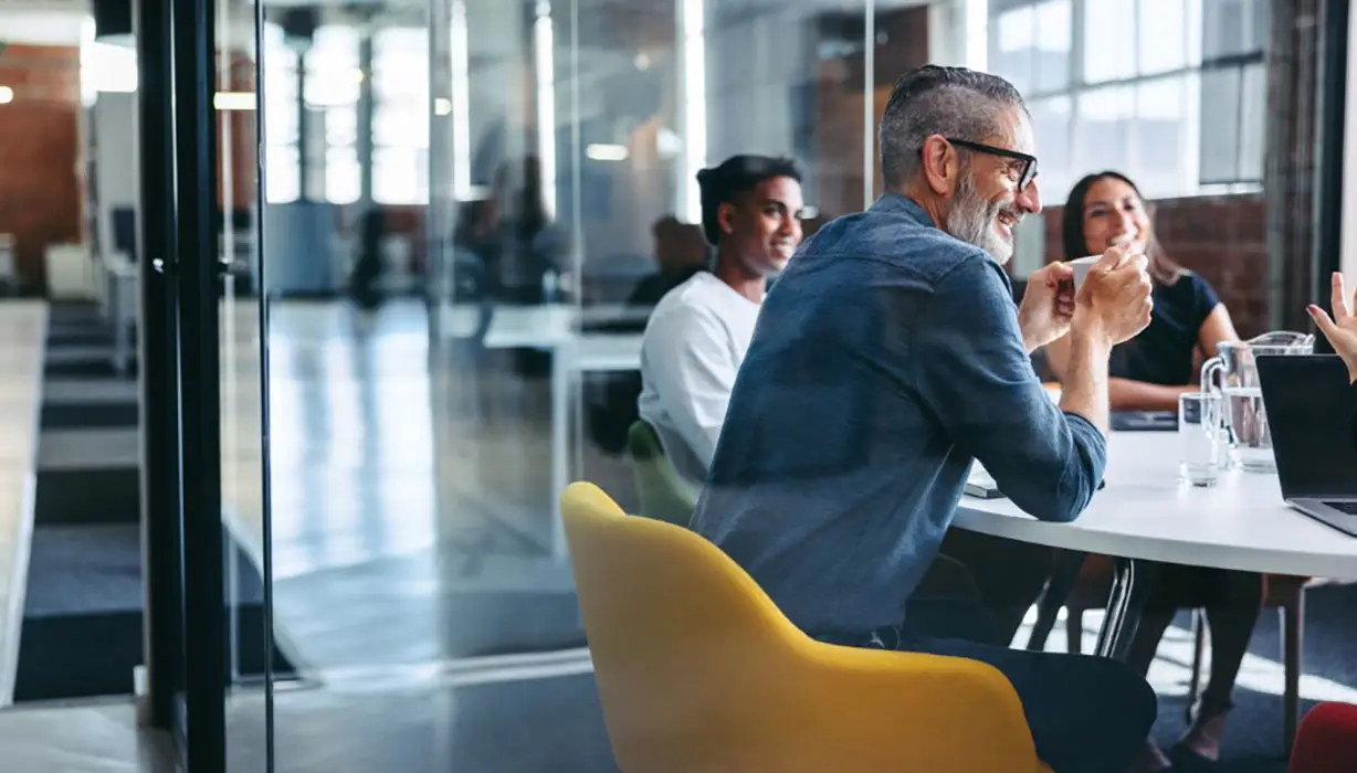 Cheerful businessman attending a meeting with his team