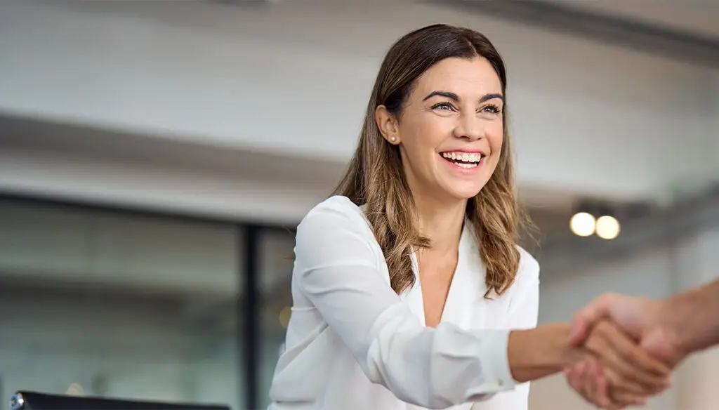 smiling woman in an office shaking hands