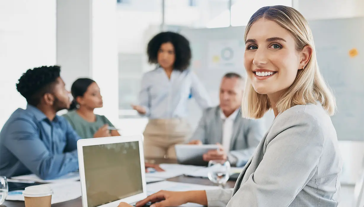 smiling woman in an office sitting at a table