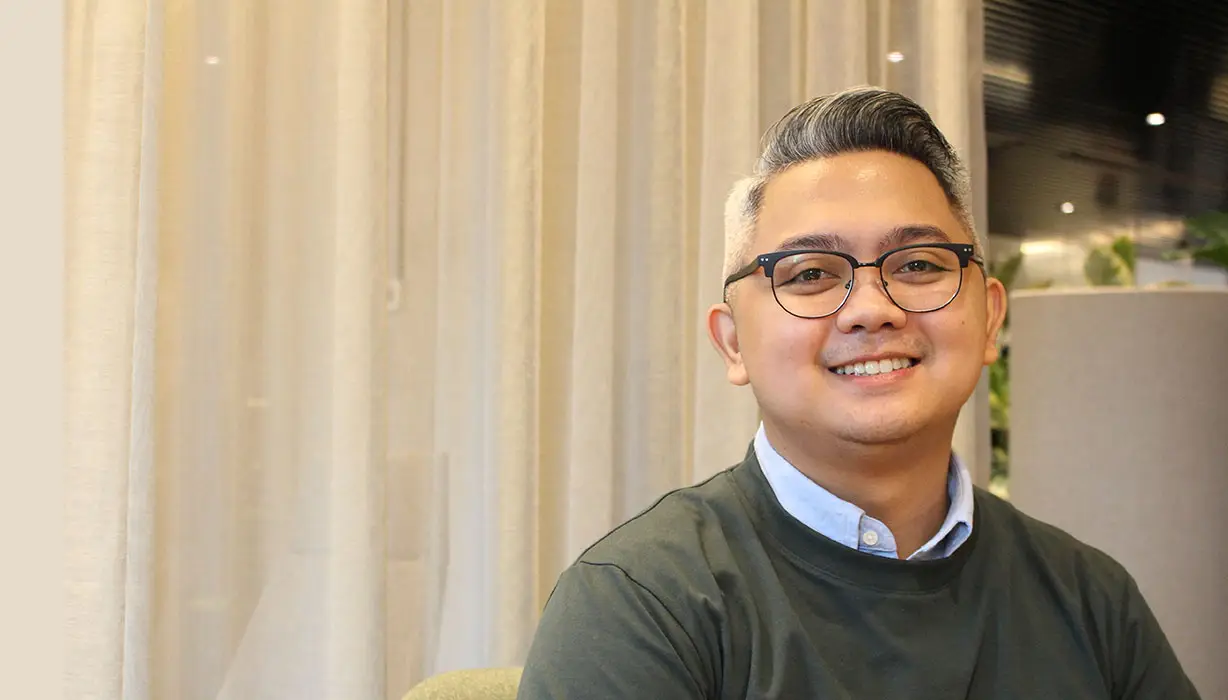 smiling man in front of curtain