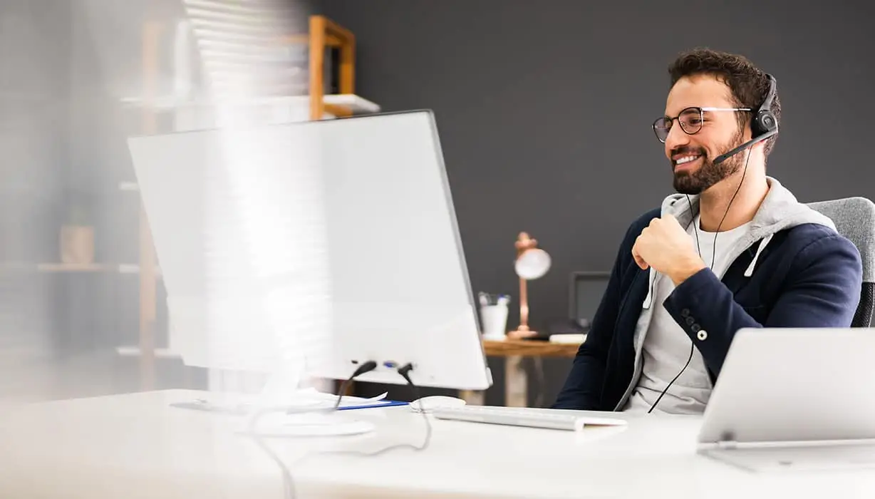 man sitting at a desk looking at a monitor